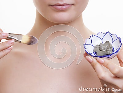 Skin care. Woman applying clay mask on face. Spa. Stock Photo