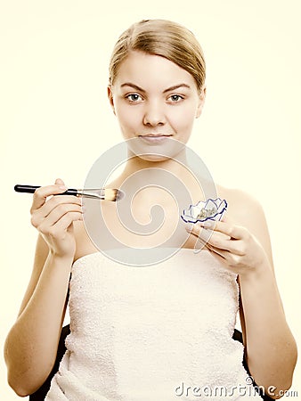 Skin care. Woman applying clay mask on face. Spa. Stock Photo