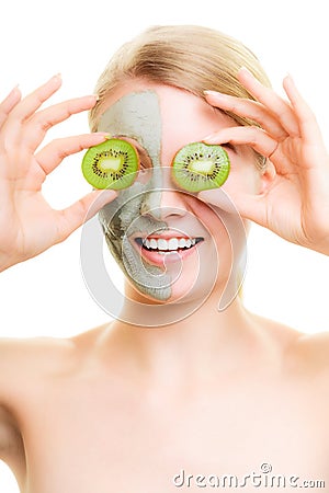 Skin care. Woman in clay mask with kiwi on face Stock Photo