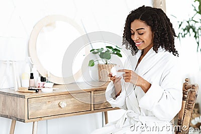 Daily Skincare. Beautiful Black Woman Using Moisturising Cream For Skin At Home Stock Photo