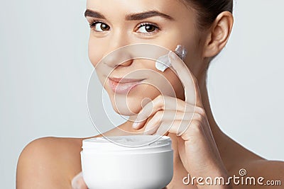 Skincare. Beauty Concept. Young pretty woman holding cosmetic cream Stock Photo