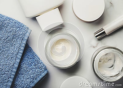 Skincare products.Cream jars,lotion, exfoliating cream and a blue towel Stock Photo