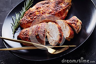 Skinless boneless chicken breasts on a black plate Stock Photo