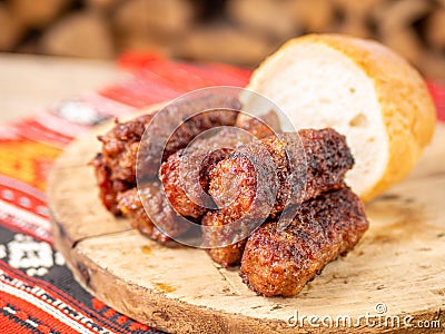 Skinless meat roll sausage or mici traditional balkan romanian ottoman cuisine delicacy served on a wooden plate in a rustic decor Stock Photo