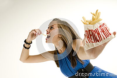 Skinny girl eating french fries Stock Photo