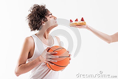 Skinny young man is seduced by sweet unhealthy food Stock Photo