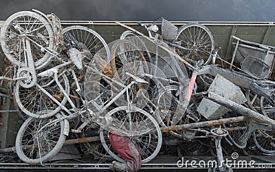 Skip with heap of rusty muddy bicycles Stock Photo