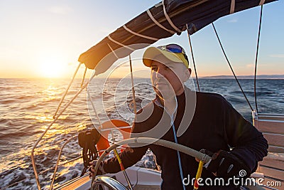 Skipper drives the sailing boat in the Aegean sea. Sport. Stock Photo