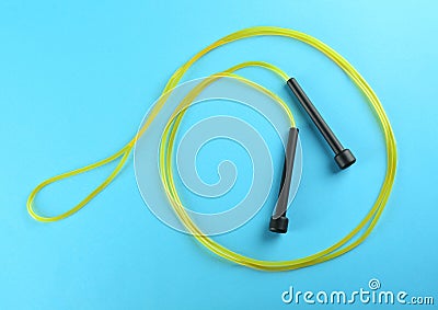 Skipping rope on light blue background, top view. Sports equipment Stock Photo