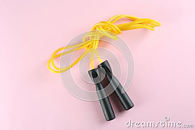 Skipping rope on light pink background, top view. Sports equipment Stock Photo