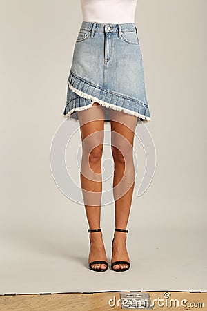 A Skirt in Blues Denim, Shorts feature a high waist, with a longer rise, relaxed leg with frayed hems, and classic five-pocket Stock Photo