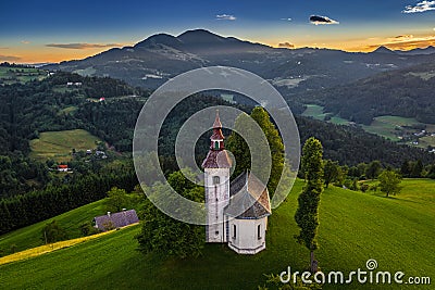 Skofja Loka, Slovenia - Aerial view of the beautiful hilltop Sveti Tomaz Saint Thomas Church with an amazing golden sunset Stock Photo