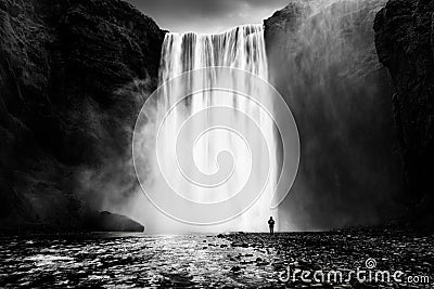 Skogafoss waterfall with a lonely man Stock Photo