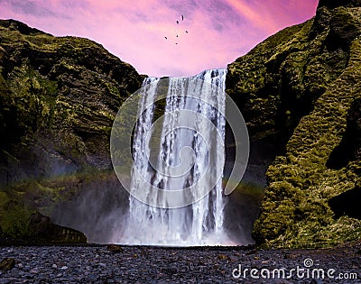 Skogafoss Waterfall underneath the pink evening sky Stock Photo