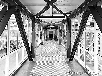 Sky bridge or transition between buildings at chemical plant above ground high-altitude crossing saving time for workers in black Stock Photo