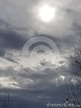Sky clouds hole storm Magical blue breeze murky dark overcast haze sleep nature tree limbs Stock Photo