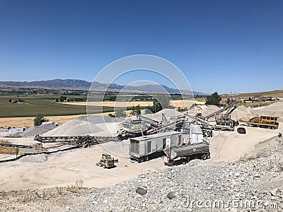 Aggregate rock crushing plant set up in with conveyors and screening plant and crusher and jaw. Beautiful summer sky. Stock Photo