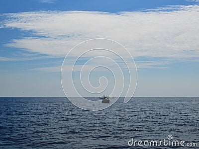 Fishing boat on the horizon of the sea Stock Photo