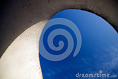 Sky shown through a curvy concrete structure . Hor Stock Photo