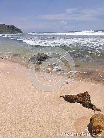 Sky, waves, coral reef, and sand in the beach Stock Photo