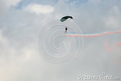 Skydiver on a para sail with red white and blue smokers. Editorial Stock Photo