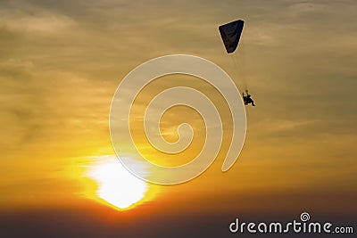 Skydiving sunset landscape of parachutist flying in soft focus. Para-motor flying silhouette with sun set. Stock Photo