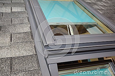 Skylight window waterproofing installation details on house asphalt shingles rooftop. Roofing construction and attic skylight Stock Photo