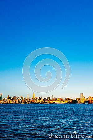 Skyline of midtown Manhattan over Hudson River under blue sky, a Stock Photo