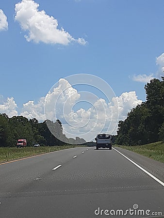 Long road with a cloudy sky and field Editorial Stock Photo