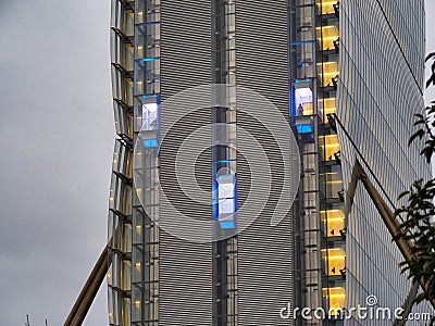 Skyscraper external elevator with persons silhouette inside Stock Photo