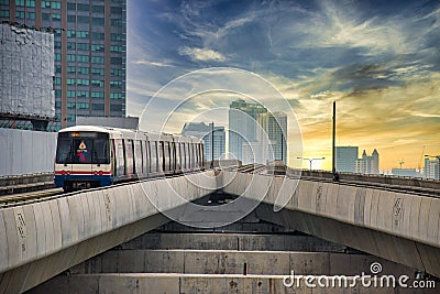 Skytrain is leaving the Ratchayothin BTS station on the Sukhumvit Line towards the blue and yellow sunset Editorial Stock Photo