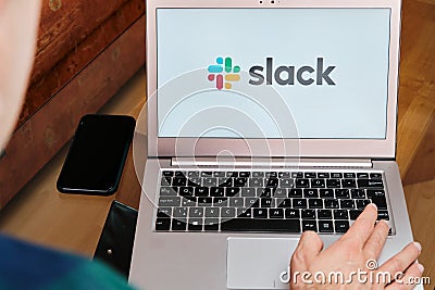 Slack is used for business meeting on laptop by man. An illustrative editorial image. San Francisco, US, June 2020 Editorial Stock Photo