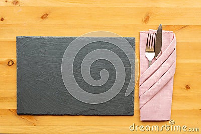 Slate place mat with knife and fork in folded napkin Stock Photo