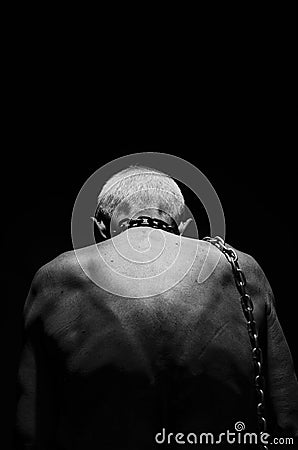 Slavery. A man tied with a chain over his neck. Stock Photo