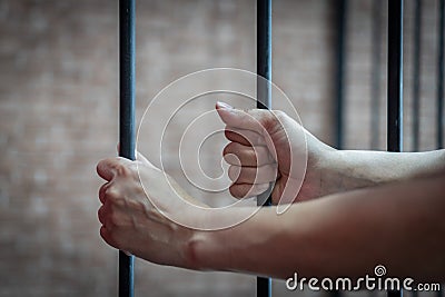 Slavery trade and trafficking victim concept with woman prisoner in jail holding bar being tortured, punished or abused Stock Photo