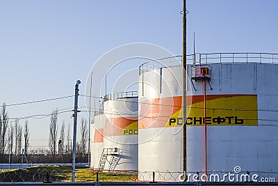 Reservoirs with fuel at the oil depot of Rosneft. Tanks in the light of the setting sun. Editorial Stock Photo