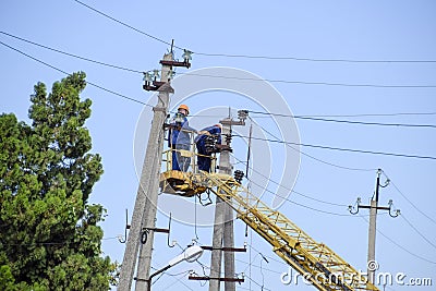 Electricians repair the power line with a lift. Repair work. Current repair of electrical wiring. Editorial Stock Photo