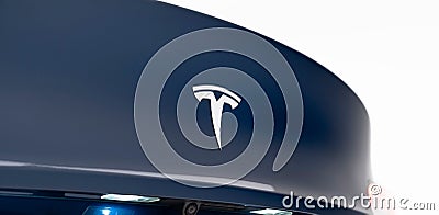 Sleek blue Tesla vehicle with a white logo on the hood, parked on a serene and sunny day Editorial Stock Photo