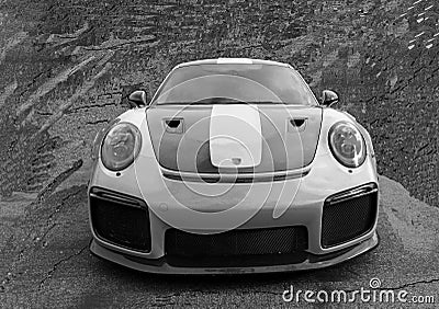 Sleek Porsche sports car parked in a gravel lot surrounded by large rocky formations Editorial Stock Photo