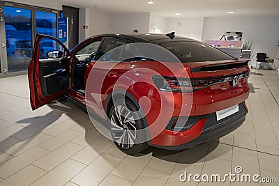 sleek Red Premium Metallic Volkswagen ID.5 GTX electric SUV parked in showroom with doors open revealing spacious and modern roomy Editorial Stock Photo