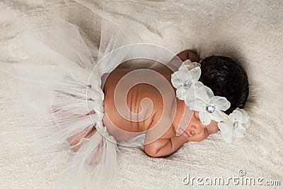 Sleeping African American Newborn With Tutu and Floral Headband Stock Photo