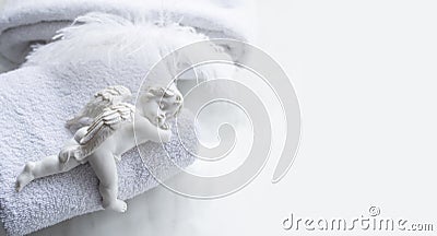 Sleeping angel figure with a bath towels and feather Stock Photo