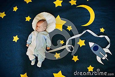 Sleeping baby boy Caucasian appearance on starry space background with rocket Stock Photo