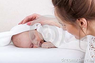 Sleeping baby and caring mother Stock Photo