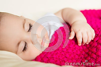 Sleeping baby covered with knitted blanket Stock Photo