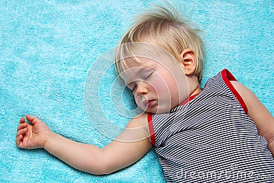 Sleeping blond haired child on blue Stock Photo