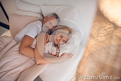 Mature couple sleeping on a bed together Stock Photo