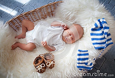 Sleeping newborn baby in basket on sheepskin Stock Photo