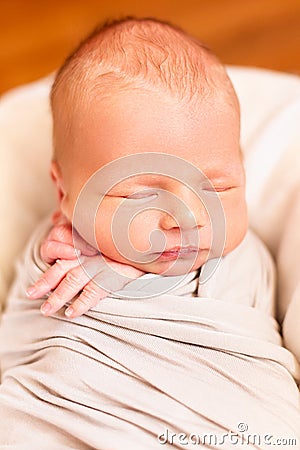 Sleeping newborn baby closeup. Small hands of the child. Baby wrap Stock Photo