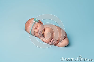 Sleeping Newborn Baby Girl with Blue Rose Headband Stock Photo